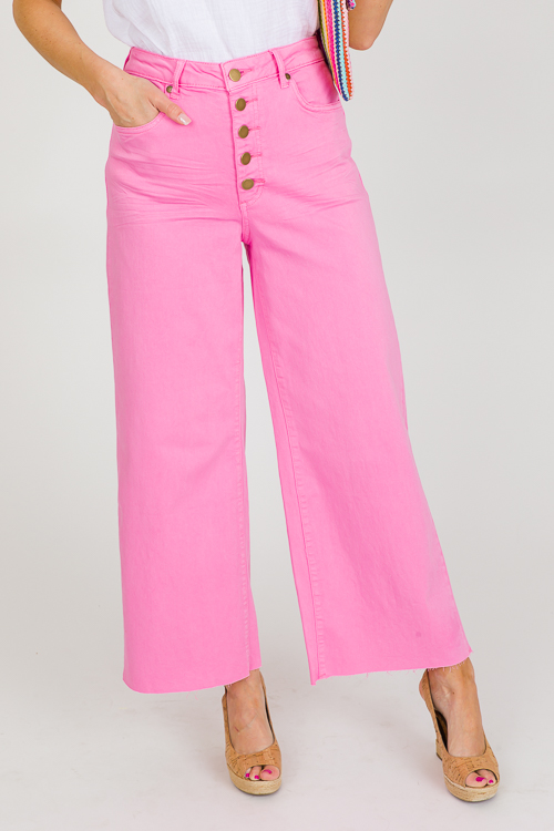 High-waisted pink jeans with visible buttons